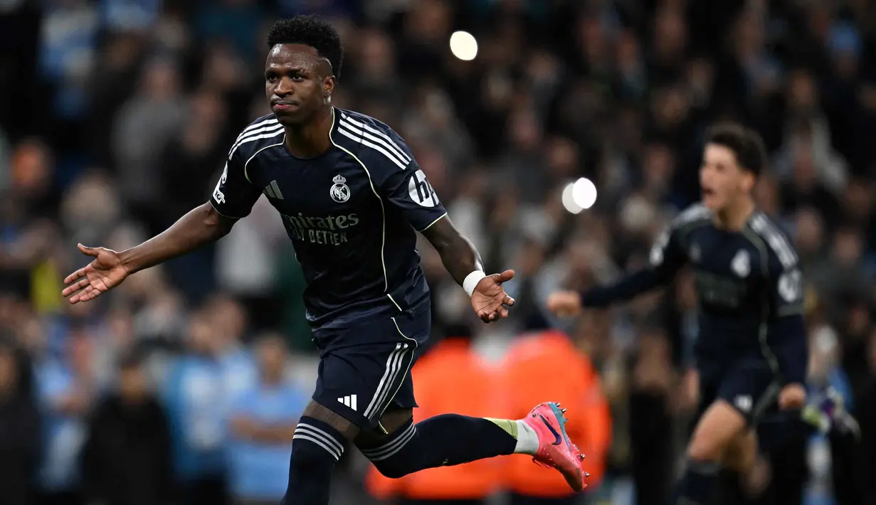 Gol penentu kemenangan Real Madrid tercipta pada menit ke-90+3 setelah Aurelien Tchouameni mengirim umpan silang akurat dari sisi kanan yang disambut Vinicius Junior. Real Madrid unggul 2-1. Tampak dalam foto, penyerang Real Madrid asal Brasil, Vinicius Junior, merayakan golnya pada pertandingan leg kedua 16 besar Liga Champions 2025/2026 melawan Manchester City di Etihad Stadium, barat laut Inggris, pada Selasa 17 Maret 2026 waktu setempat atau Rabu (18/3) dini hari WIB. (Paul ELLIS/AFP)