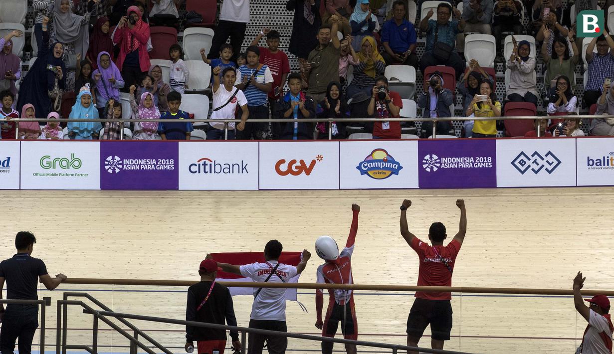 Selebrasi M Fadli pebalap sepeda Indonesia yang meraih medali emas di nomor 4000 meter Individual Pursuit C4 di Velodrome Rawamangun, Jakarta,  Jumat (11/10/2018).  (Bola.com/Peksi Cahyo)