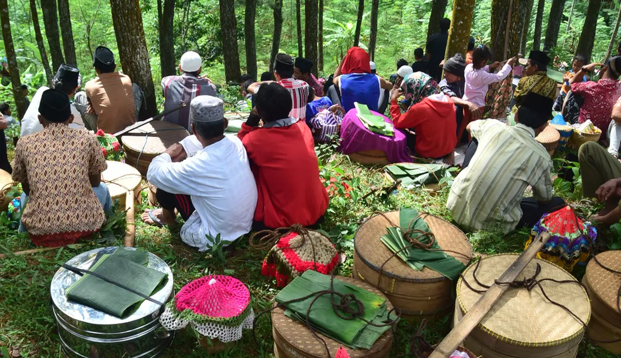 Warga mengikuti prosesi Sadranan Asyura di makam kiai kramat di bukit Tlogo Pucang, Kandangan, Temanggung, Rabu  (12/10).  Warga berdatangan sambil membawa tenongan berisi makanan yang didoakan dan kemudian di makan bersama. (Liputan6.com/Gholib)