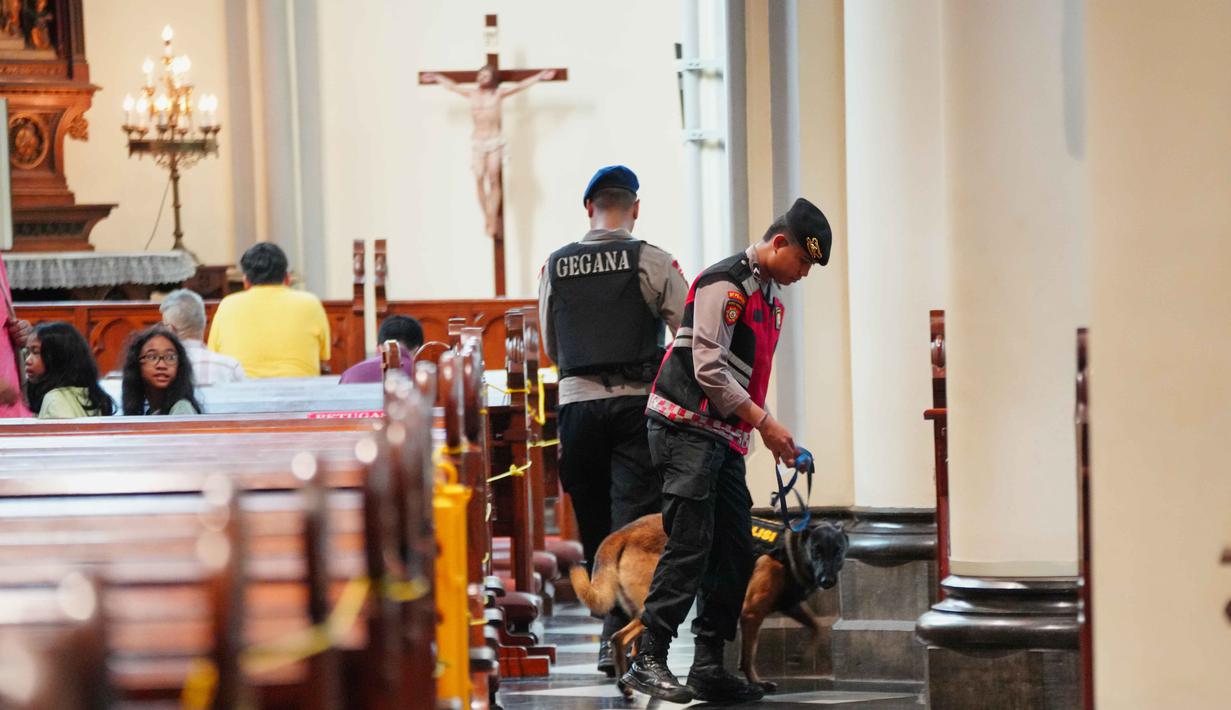 Sebagai informasi, Gereja Katedral Jakarta akan menggelar Misa malam Natal pada Rabu (24/12/2025) pukul 17.00 WIB dan 20.00 WIB. Sementara Misa Hari Raya Natal terbagi ke dalam tiga sesi pada Kamis 25 Desember 2025 mendatang. Tampak dalam foto, personel dari unit K9 kepolisian Indonesia menggeledah deretan kursi di dalam gereja selama operasi pengamanan menjelang perayaan Natal di Katedral Bunda Maria Diangkat ke Surga atau Gereja Katedral Jakarta, Selasa 23 Desember 2025. (AP Photo/Tatan Syuflana)