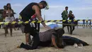 Wanita bernama  Eliane mencium suaminya yang tewas Eduardo Marinho Albuquerque di pantai, Rio de Janeiro , Brasil , 21 April 2016. Dua orang tewas dalam peristiwa runtuhnya bangunan ini. (REUTERS / Ricardo Moraes) 