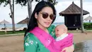 Sama halnya dengan yang satu ini, Titi tetap kece memakai baju hijau dan kacamata hitsnya sambil menggendong Kai menggunakan gendongan berwarna pink. Mesra banget ya ibu dan anak ini? (Instagram/titi_kamall)