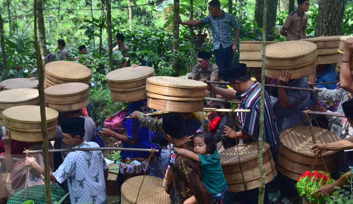 Sejumlah warga membawa tenongan yang berisi makanan saat mengikuti prosesi Sadranan Asyura di makam kiai kramat yang berada di bukit Tlogo Pucang, Kandangan, Temanggung,  Rabu  (12/10).  (Liputan6.com/Gholib)