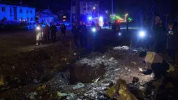 Permukiman warga sipil kembali menjadi sasaran serangan drone Rusia yang terjadi pada Kamis 16 April 2026 dini hari waktu setempat. Tampak dalam foto, warga melihat lubang tanah akibat serangan Rusia di permukiman penduduk, Kyiv, Ukraina, pada Kamis 16 April 2026. (AP Photo/Evgeniy Maloletka)