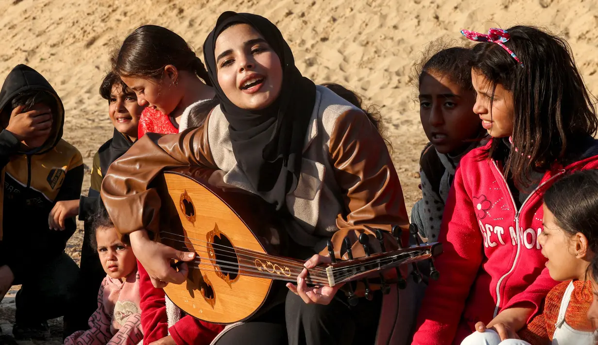 Ruaa Hassouna berusaha menghibur anak-anak penyintas perang Hamas-Israel. (SAID KHATIB/AFP)