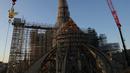 Ayam jago emas baru berisi relik diangkat dengan derek untuk dipasang di puncak menara Katedral Notre Dame sebagai bagian dari rekonstruksi, di pusat kota Paris, Sabtu (16/12/2023). (Thomas SAMSON / AFP)