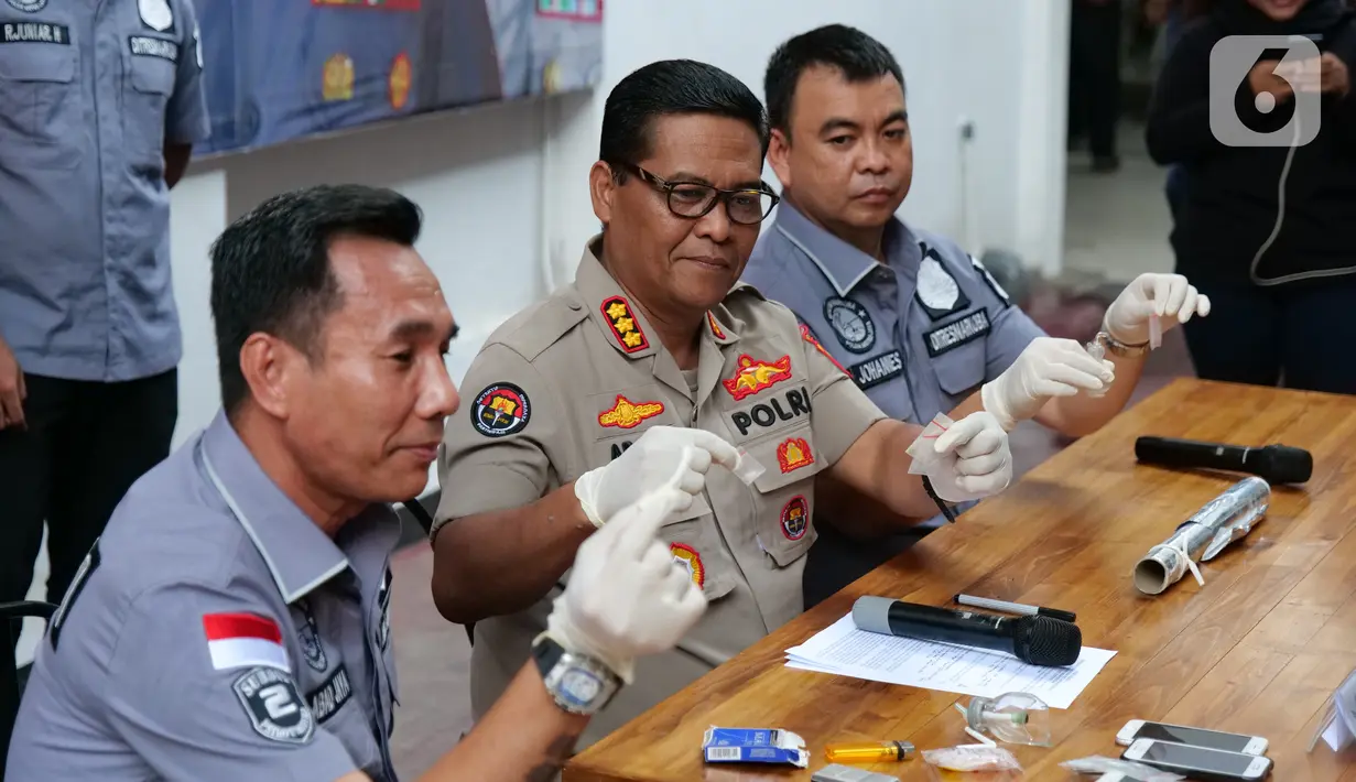 Kabid Humas Polda Metro Jaya Kombes Pol Argo Yuwono (tengah) menunjukkan barang bukti kasus narkoba yang menjerat sutradara Amir Mirza Gumay saat rilis di Polda Metro Jaya, Jakarta, Kamis (17/10/2019). Polisi menyita sabu seberat 0,37 gram dan ganja 0,69 gram. (Liputan6.com/Herman Zakharia)