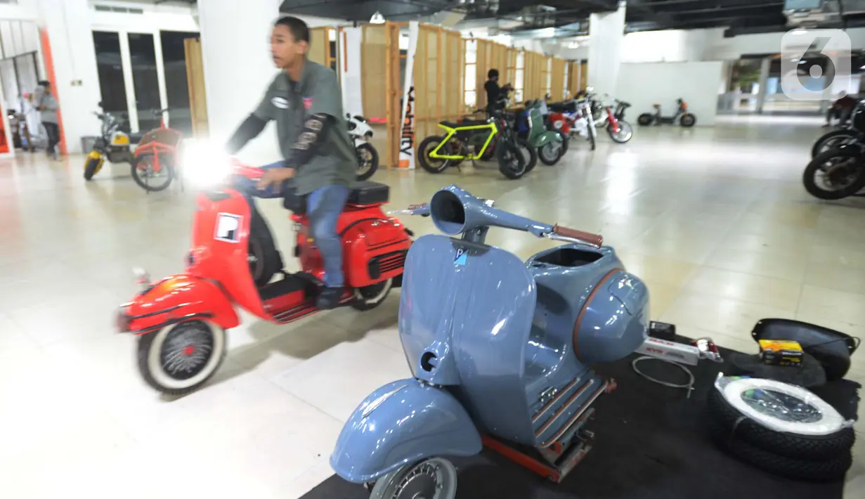 Seorang mekanik membawa motor yang sudah dimodifikasi motor di Jakarta, Selasa (29/3/2022). Modifikasi motor tersebut merupakan konversi  bahan bakar minyak ke motor listrik. (merdeka.com/Imam Buhori)