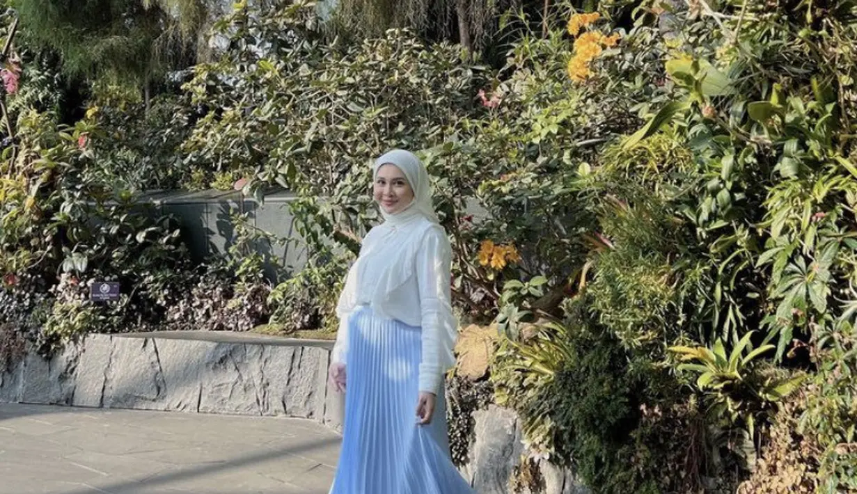 Selain dress, bisa juga tampil dengan kemeja putih yang serasi dengan kerudungnya, dipadukan plisket biru. (@kesharatuliu05)
