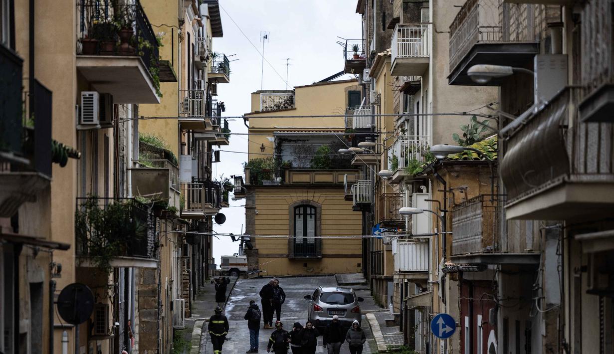 Otoritas Italia, pada Senin, 26 Januari, menetapkan status darurat nasional, menyusul dampak mematikan siklon Harry yang menerjang wilayah Calabria, Sisilia, dan Sardinia sejak awal pekan lalu. Tampak dalam foto, petugas pemadam kebakaran membantu para pengungsi mengumpulkan barang-barang mereka di rumah-rumah mereka yang terletak di zona merah Niscemi, Sisilia, Kamis 29 Januari 2026. (MARCO BERTORELLO/AFP)
