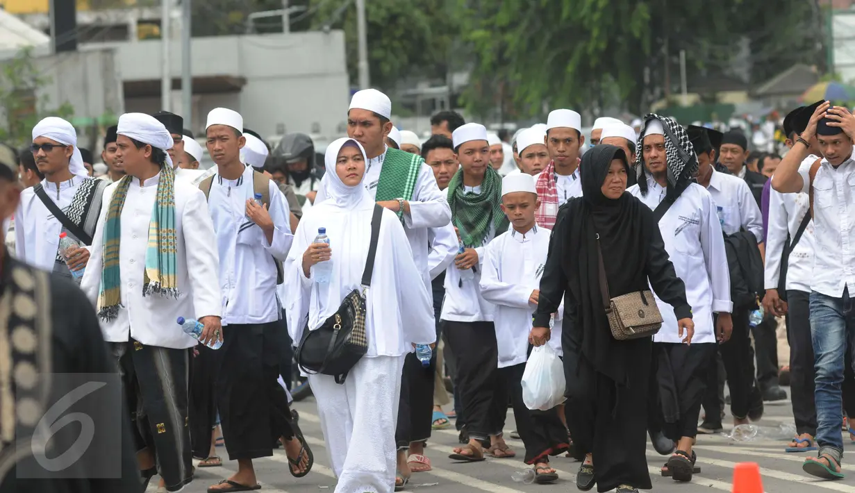 Peserta demo 2 Desember terlihat masih berjalan menuju Monas dari arah Tanah Abang, Jakarta, Jumat (2/12). Tidak hanya kaum pria, tampak kaum perempuan juga turut dalam aksi doa bersama di Monas. (Liputan6.com/Helmi Afandi)