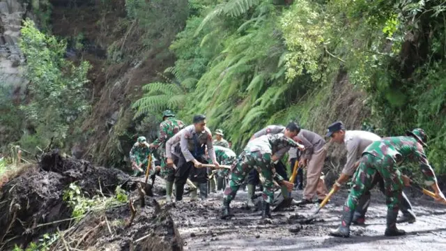 Aparat Polisi dan TNI membersihkan longsoran tana yang menutup akses ajalan di kawasan Taman Nasional Bromo Tengger Semeru (Istimewa)