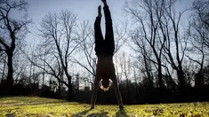 Marco Amantini melakukan handstand di rerumputan dekat Great Lawn di pusat Central Park, di wilayah Manhattan, New York, Senin (30/1/2023). Sejak awal musim dingin di bulan Desember, belum ada hujan salju yang terkira di kota. (AP Photo/John Minchillo)