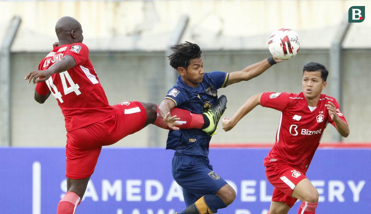 Pemain Persik Kediri, Onorionde Kughegbe (kiri), menghadang laju pemain Persela Lamongan, Riyatno Abiyoso (tengah) dalam pertandingan Babak Penyisihan Piala Menpora 2021 Grup C di Stadion Si Jalak Harupat, Bandung, Rabu (7/4/2021). (Foto: Bola.com/Ikhwan Yanuar)