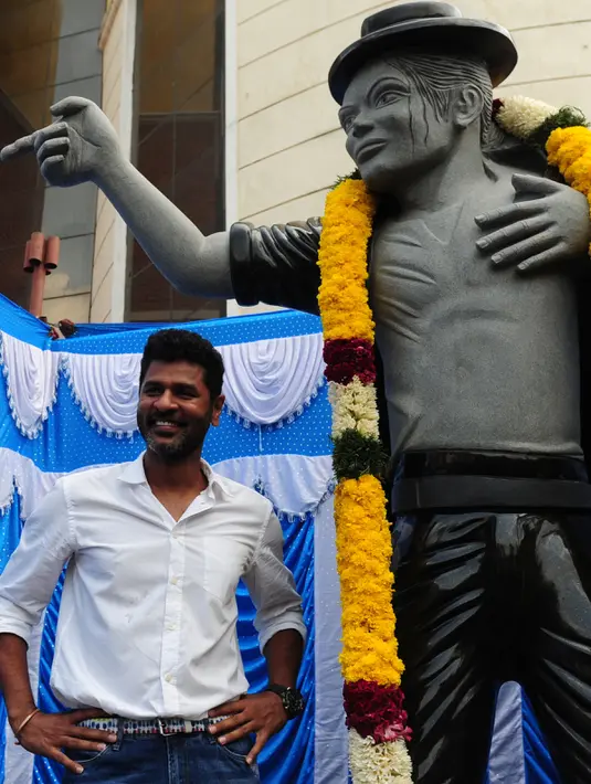 Seorang pria mengambil foto bersama patung bintang pop AS Michael Jackson di Chennai, India, Kamis (7/4). Patung ini dibangun disebuah Universitas ternama di India. (Arun Sankar/AFP)