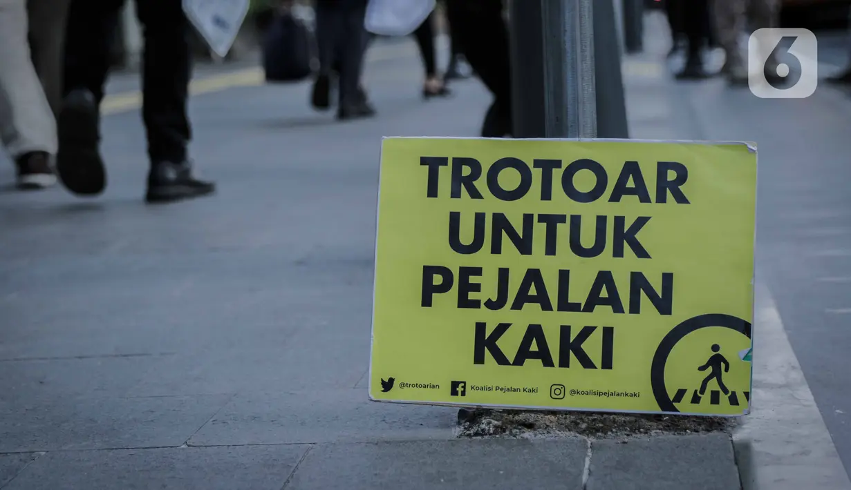 Poster bertuliskan Trotoar Untuk Pejalan Kaki terlihat di Trotoar Thamrin, Jakarta, Rabu (22/1/2020). Aksi tersebut dalam rangka memperingati Hari Pejalan Kaki Nasional pada 22  Januari, serta  mengajak pengendara untuk tertib lalu lintas serta menghormati hak pejalan kaki. (Liputan6.com/Faizal Fana