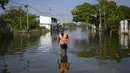 Seorang pria mengarungi jalan-jalan yang tergenang air di Mata Redonda, Maracay, Venezuela, Rabu (21/10/2020). Lusinan keluarga mencari perlindungan di atap rumah mereka untuk melindungi barang pribadi mereka. (AP Photo/Matias Delacroix)