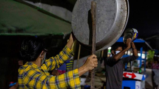 Warga memukul kaleng, panci, dan wajan untuk membuat keributan memprotes kudeta militer di Yangon, Myanmar, 2 Februari 202. Militer Myanmar menolak kemenangan telak NLD dalam pemilihan umum pada 8 November lalu dengan tuduhan penipuan yang tidak berdasar. (STR/AFP)