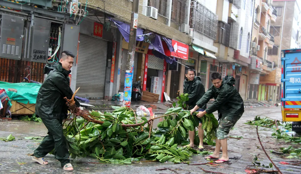 Warga memindahkan pohon tumbang akibat Topan Mujigae di Maoming, Provinsi Guangdong, China, Minggu (4/10/2015). Topan dengan kecepatan angin hingga 180 km per jam menghantam pantai selatan China dan menewaskan sedikitnya empat orang. (REUTERS/Stringer)