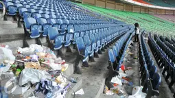 Petugas kebersihan membersihkan tumpukan sampah usai pertandingan final piala presiden di Stadion GBK, Jakarta (19/10/15). Pertandingan final tersebut dimenangkan oleh Persib Bandung 2-0. (Liputan6.com/Gempur M Surya).