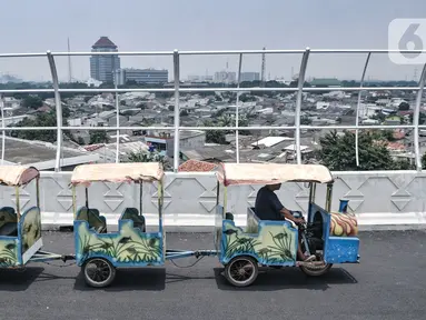 Odong-odong saat melintas di Flyover Cakung, Jakarta, Selasa (16/3/2021).  Progres pembangunan flyover yang menghubungkan kawasan Duren Sawit dengan Cakung tersebut saat ini telah mencapai 96,44 persen. (merdeka.com/Iqbal S. Nugroho)