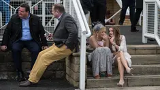 Dua penggemar balap kuda atau racegoers saat menghadiri pembukaan Festival Grand National di arena Aintree, Liverpool, Inggris (7/4). Kehadiran racegoers memberikan nuansa tersendiri di kompetisi pacuan kuda terbesar tersebut. (AFP Photo / Oli Scarff)