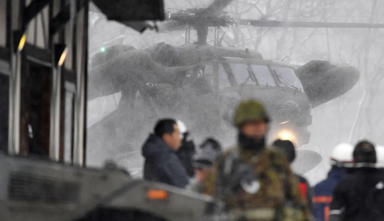 Sebuah helikopter Angkatan Pertahanan Jepang (SDF) terbang di sebuah resor ski setelah terjadi letusan Gunung Kusatsu-Shirane di Kusatsu, Jepang, Selasa (23/1). Petugas bersiap melakukan penyelamatan para korban. (Muneyuki Tomari/Kyodo via AP)