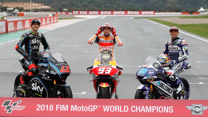 Juara Dunia MotoGP Marc Marquez (tengah) berpose bersama Juara Dunia Moto2 Francesco Bagnaia (kiri) dan Juara Dunia Moto3 Jorge Martin (kanan) usai Grand Prix Valencia di sirkuit Ricardo Tormo, Cheste, Spanyol, Minggu (18/11). (AP Photo/Alberto Saiz)