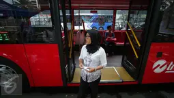 Seorang petugas bus tingkat wisata TransJakarta mengenakan kebaya saat menjalankan tugasnya di Jakarta, Jumat (21/4). Dalam rangka Hari Kartini, semua pramudi perempuan bus pariwisata dan Transjakarta mengenakan kebaya. (Liputan6.com/Faizal Fanani)