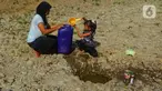Seorang anak bersama ibunya mengambil air pada galian sumur di tengah aliran Sungai Cihoe, Kamis (28/9/2023). Warga Desa Sukagalih, Jonggol, Bogor, mengalami kesulitan air bersih di tengah fenomena El Nino yang menyebabkan musim kemarau berkepanjangan. (merdeka.com/Arie Basuki)