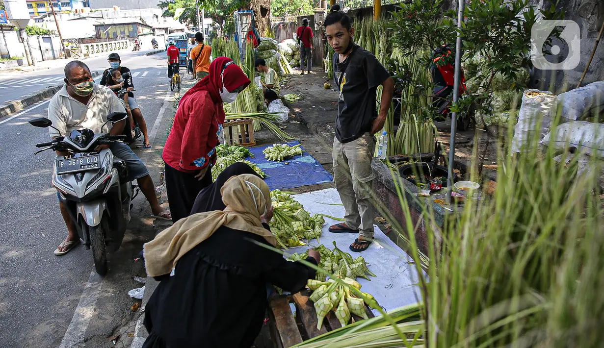 Pedagang cangkang ketupat melayani pembeli di kawasan Palmerah, Jakarta, Minggu (18/7/2021). Sepinya pembeli membuat para pedagang menjual cangkang ketupat hanya dengan harga Rp 5 ribu per ikat, padahal biasanya Rp 8 ribu per ikat. (Liputan6.com/Faizal Fanani)