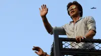 Aktor Bollywood, Shahrukh Khan melambaikan tangan kepada  para fans yang berkumpul dari balkon rumahnya di Mumbai, Kamis (2/11). Bagi warga India, datang ke kediaman SRK pada ulang tahunnya sudah menjadi tradisi penggemar. (Sujit Jaiswal/AFP Photo)