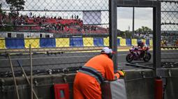 Seorang pmbalap terlihat di antara jendela marshal dalam ajang 24 Hours of Le Mans yang berlangsung di Sirkuit Bugatti, Prancis, 18 April 2026 waktu setempat. (AFP/Julien De Rosa)