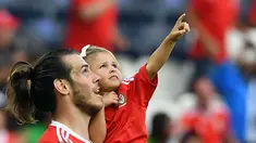 Pemain Wales, Gareth Bale menggendong putrinya usai laga melawan Irlandia Utara pada Piala Eropa 2016 di Parc des Princes, Paris, (25/6/2016). Wales Menang 1-0.  (EPA/Georgi Licovski)