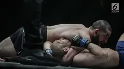 Petarung Rusia, Yusup Saadulaev (atas) beraksi melawan petarung Jepang, Masakazu Imanari dalam laga One Championship di Jakarta Convention Center (JCC), Sabtu (20/1). Pertarungan tersebut dimenangkan oleh Yusup Saadulaev. (Liputan6.com/Faizal Fanani)