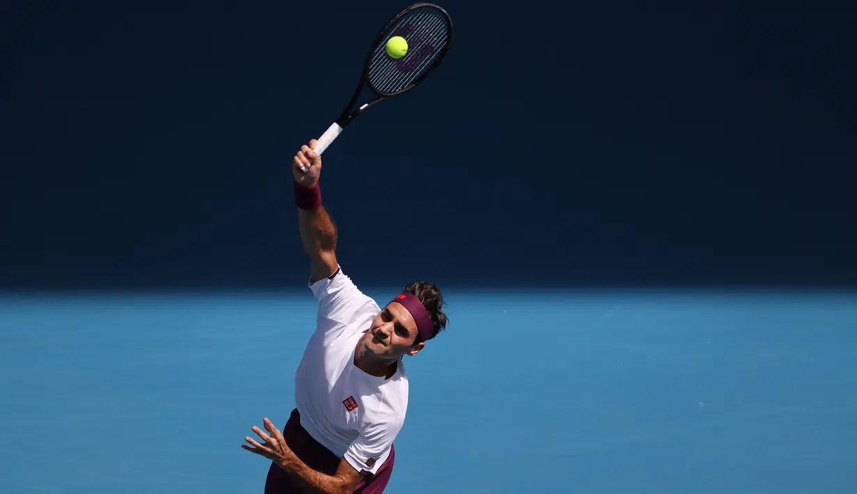 Petenis Swiss, Roger Federer, mengembalikan bola saat melawan petenis AS, Tennys Sandgren, pada perempat final Australia Open 2020 di Melbourne, Selasa (28/1). Federer menang 6-3, 2-6, 2-6, 7-6 (10-8), 6-3 atas Sandgren. (AFP/David Gray)