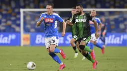 Pemain Napoli Piotr Zielinski (kiri) dan pemain Sassuolo Francesco Manganelli berebut bola pada pertandingan Serie A di Stadion San Paolo, Naples, Italia, Sabtu (25/7/2020). Napoli mengalahkan Sassuolo dengan skor 2-0. (Cafaro/LaPresse via AP)