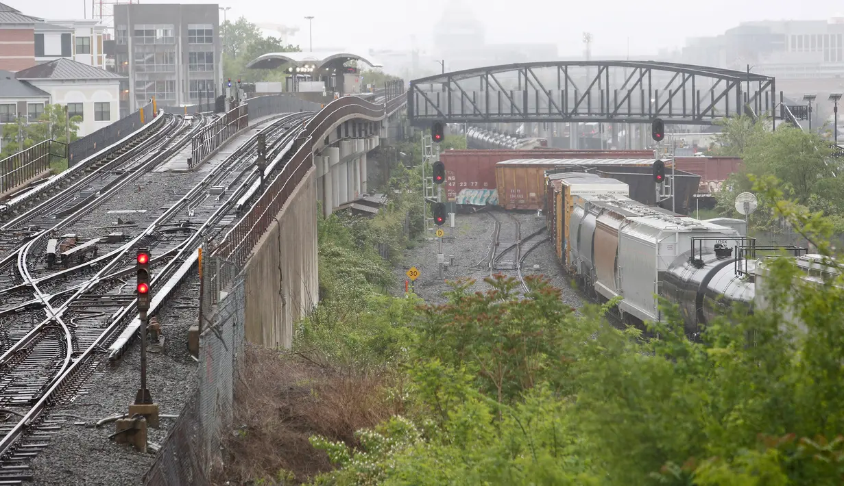 Sebuah kereta barang CSX keluar dari rel di bagian timur laut Washington, Minggu (1/5) waktu setempat. Kereta ini menumpahkan zat kimia berbahaya dekat stasiun bawah tanah dan mengganggu lalu lintas kereta api bawah tanah. (Andrew BIRAJ /AFP)