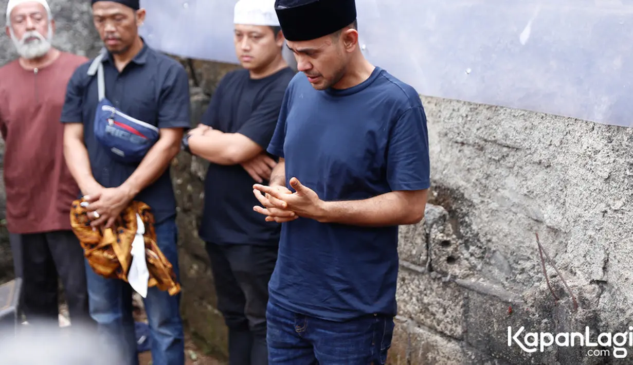 Tatapan Ramzi menyaksikan jenazah sang ibu yang secara perlahan tertutup rata dengan tanah. Setelah selesai, tangis Ramzi pecah ketika menyampaikan pesan-pesan kepada para pelayat. [Foto: Budy Santoso/KapanLagi.com]