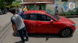Anggota Karang Taruna menyemprotkan cairan disinfektan ke kendaraan yang memasuki pemukiman di Kelurahan Kebon Sirih, Jakarta, Rabu (1/4/2020). Warga di kelurahan itu memberlakukan akses satu pintu masuk dan menyemprotkan disinfektan guna mencegah penyebaran virus COVID-19. (merdeka.com/Imam Buhori)