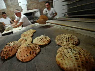 Pekerja membuat somun di sebuah toko roti di kota tua Sarajevo, Bosnia and Herzegovina, Kamis (30/4/2020). Somun merupakan roti tawar tradisional  asal Bosnia yang dibuat sejak abad ke-16 di Sarajevo. (ELVIS BARUKCIC/AFP)