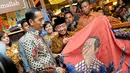 Presiden terpilih Joko Widodo melihat batik bercorak dirinya, Pasaraya Blok M, Jakarta, Kamis (2/10/2014) (Liputan6.com/Herman Zakharia)