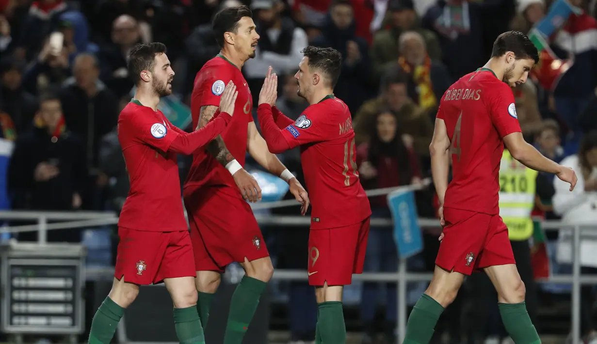 Gelandang Portugal, Bernardo Silva (kiri) berselebrasi dengan rekannya usai mencetak gol ke gawang Lithuania pada pertandingan Grup B Kualifikasi Piala Eropa 2020 di stadion Algarve di luar Faro, Portugal (14/11/2019). Portugal menang besar 6-0 atas Lithuania. (AP Photo/Armando Franca)