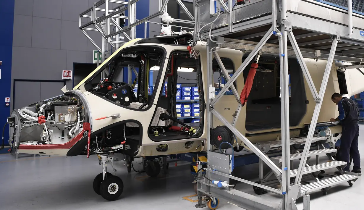 Suasana saat karyawan perusahaan Leonardo Helicopters merakit helikopter AgustaWestland AW189 di Vergiate, dekat Milan, Italia, Selasa (30/1). AgustaWestland AW189 sangat cocok untuk operasional SAR maupun mengangkut personel. (MARCO BERTORELLO/AFP)