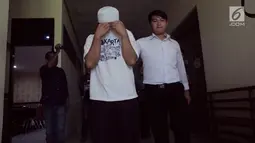 Salah satu tersangka dikawal petugas sebelum konferensi pers terkait narkoba di  Polda Gorontalo, Senin (13/5/2019). Dari tangan WR yang teridentifikasi merupakan oknum staf di salah satu Politeknik di Gorontalo, polisi mengamankan narkoba jenis sabu-sabu. (Liputan6.com/Arfandi ibrahim)