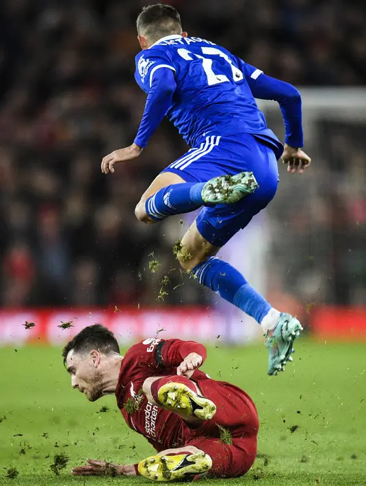 Bek Leicester City Timothy Castagne (atas) melompati bek Liverpool Andrew Robertson pada pertandingan pekan ke-18 Liga Inggris di Stadion Anfield, Sabtu (31/12/2022) dini hari WIB. Liverpool tampak cukup kesulitan menemukan ritme terbaik mereka setelah hampir sebulan tidak bertanding. (Photo by Oli SCARFF / AFP)