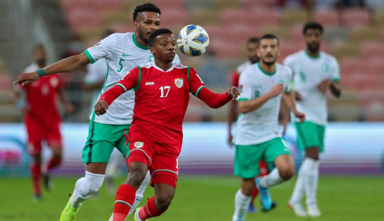Pemain Oman Arshad al-Alawi (tengah) dibayangi pemain Arab Saudi Ali al-Bulaihi (kiri) pada pertandingan sepak bola Kualifikasi Piala Dunia 2022 di Stadion King Abdullah Sport City, Jeddah, Arab Saudi, 27 Januari 2022. Arab Saudi menang 1-0. (AFP)