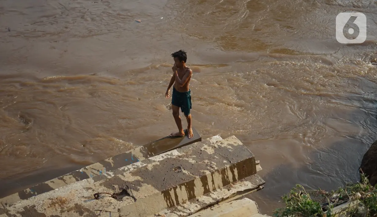 Anak-anak berenang di bantaran Sungai Ciliwung, Jakarta, Senin (5/10/2020). Derasnya aliran Sungai Ciliwung akibat hujan deras yang mengguyur Jakarta tidak menyurutkan kemauan anak-anak tersebut untuk tetap berenang, meski dapat membahayakan keselamatan mereka. (Liputan6.com/Immanuel Antonius)