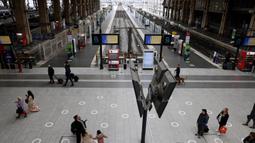 Sejumlah pelancong berjalan melewati layar informasi saat lalu lintas terganggu di stasiun kereta Gare du Nord pada hari kedua pemogokan nasional dan protes terhadap rencana reformasi pensiun pemerintah di Paris, Selasa (31/1/2023). Operator transportasi ibu kota RATP mengatakan sebagian besar layanan kereta bawah tanah dan metro Paris akan sangat dibatasi. (Ludovic MARIN/AFP)