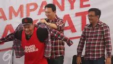 Cagub Basuki T Purnama dan Cawagub DKI Jakarta Djarot Saiful Hidayat memakaikan kemeja ke penyanyi rap Iwa K di Rumah Lembang, Jakarta, Senin (28/11). Sejumlah penyanyi rap turut meramaikan kampanye rakyat tersebut. (Liputan6.com/Immanuel Antonius)